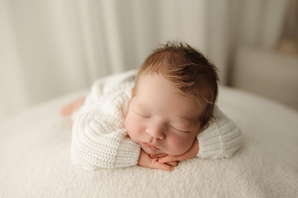 Newborn photographer safely posing and photographing a baby during a studio session