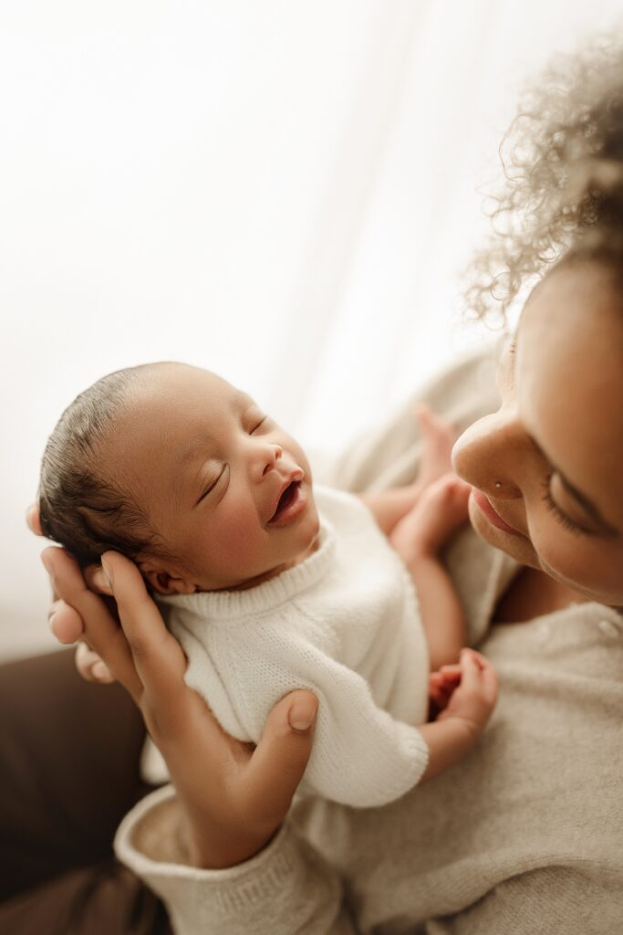 Parents cuddling their newborn baby during a professional newborn photography session